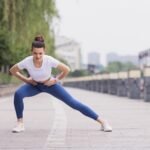 Slim woman in sportswear stretching outdoors before fitness training or jogging