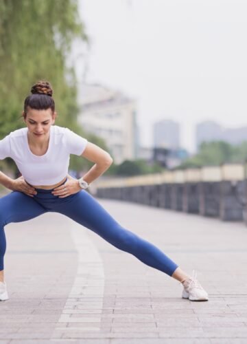 Slim woman in sportswear stretching outdoors before fitness training or jogging