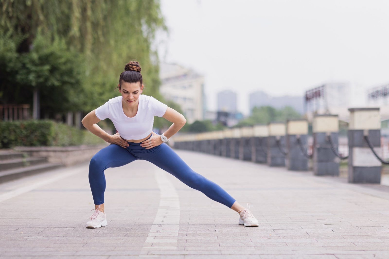 Slim woman in sportswear stretching outdoors before fitness training or jogging