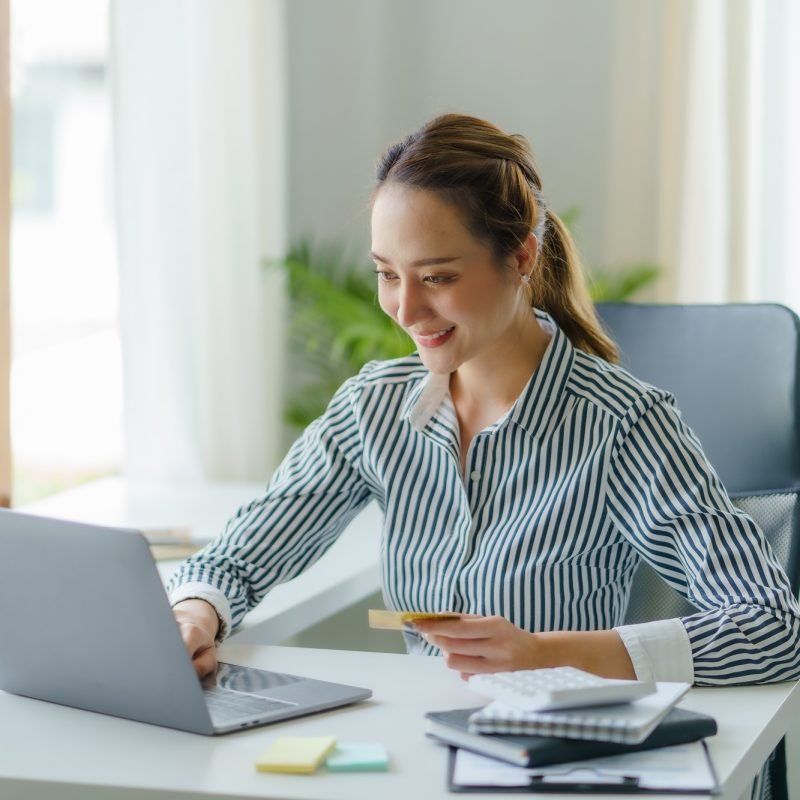 Asian businesswoman using laptop to check balance and online shopping enjoy online shopping